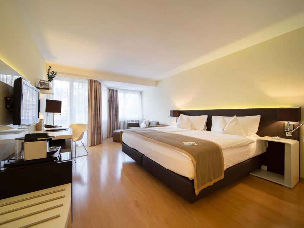 巴塞尔Hotel Spalentor - Ihr sympathisches Stadthotel的酒店客房设有一张大床和一张书桌。