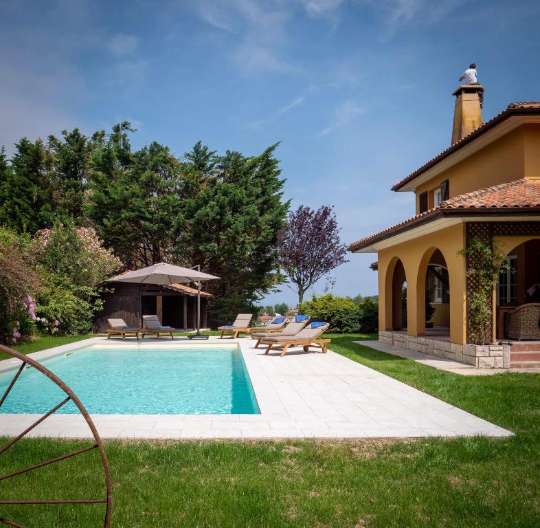 昂代Villa Enara的一个带游泳池和房子的后院