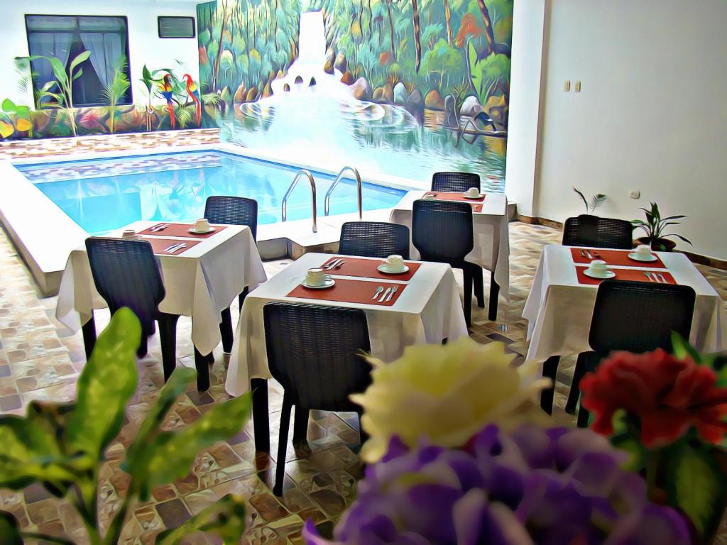 塔拉波托Residencial Lago Verde的一间带桌椅的餐厅和一个游泳池