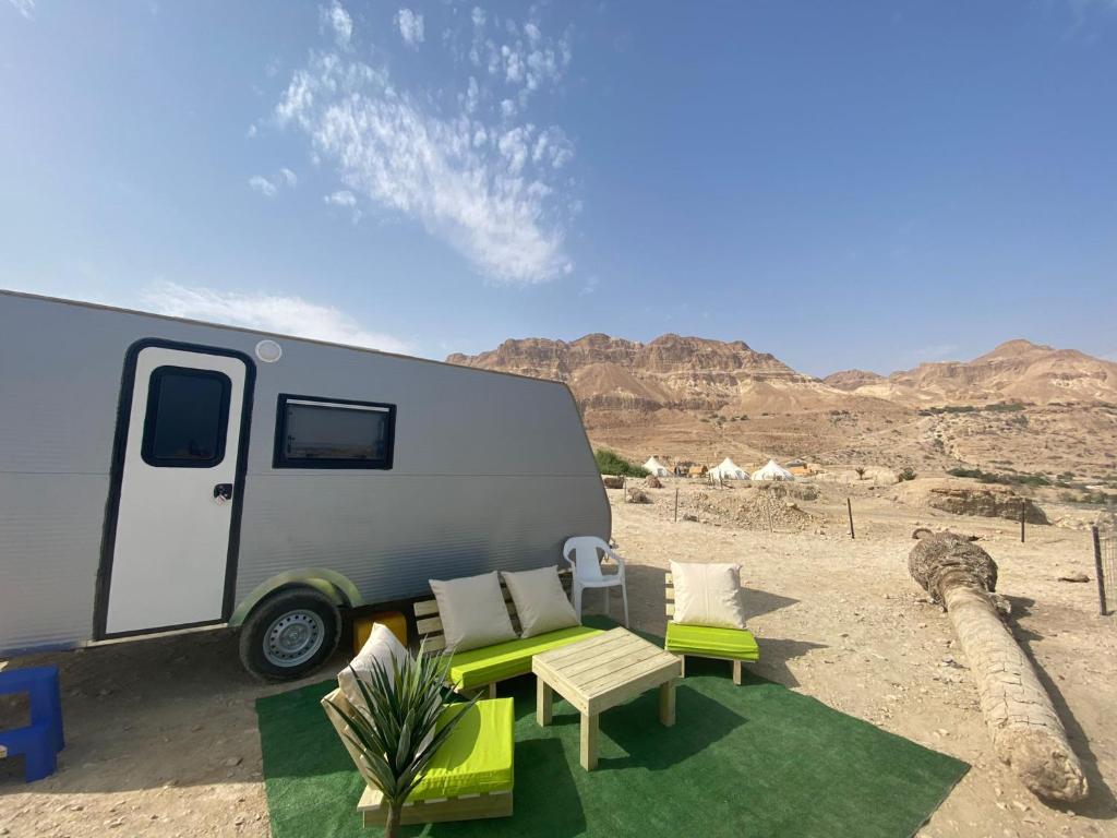 基布兹恩戈蒂Ein Gedi caravan by Dory caravan的沙漠中停放的带桌椅的大篷车