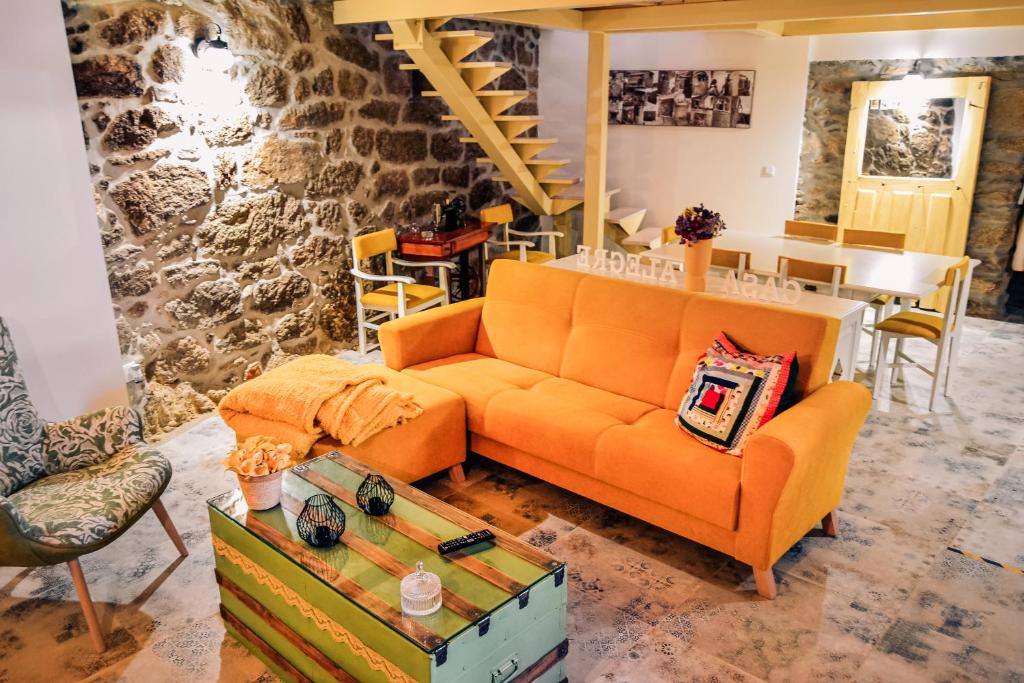 米兰达·杜·杜罗A Casa Alegre的客厅配有橙色沙发和桌子