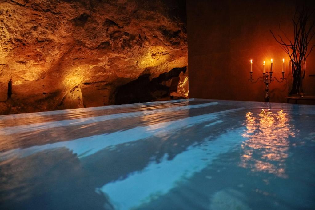 锡拉库扎UNAHOTELS One Siracusa的洞穴中的游泳池,有两根蜡烛