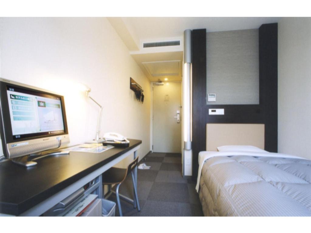东京R&B Hotel Tokyo Toyocho - Vacation STAY 40490v的酒店客房配有一张床和一张带电脑的书桌
