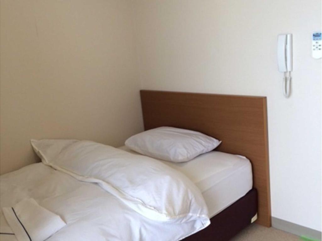 德之岛Yugaku Resort Kimukura - Vacation STAY 89356v的一张带白色床单和枕头的床