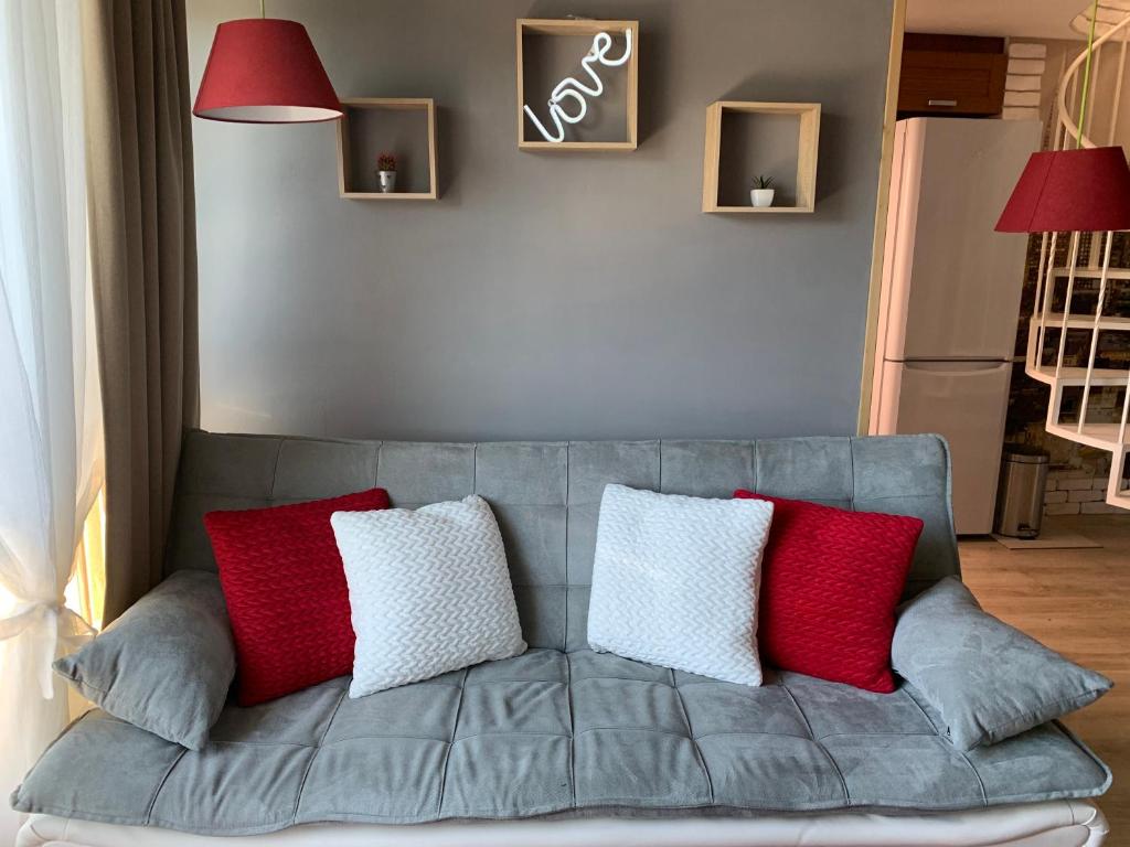 索非亚Lovely penthouse with an indoor fireplace的灰色的沙发上配有红色和白色枕头