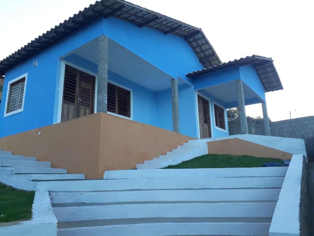 伊卡普伊Pousada Chalés do Castelo的蓝色房子前面有楼梯
