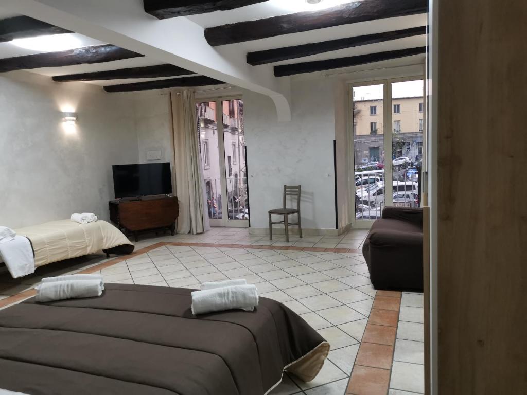 那不勒斯那不勒斯住宿加早餐旅馆的一间卧室配有一张床、一张沙发和一台电视。