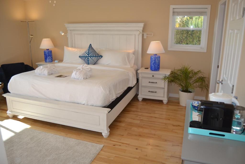 West KelownaSalish B&B and Spa的一间卧室配有白色床、两个床头柜和电视
