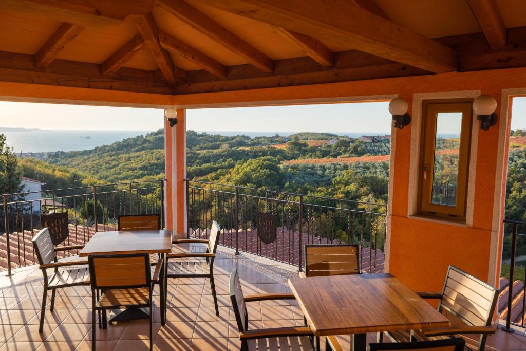 HrvatiniGordia organic winery的阳台配有桌椅,享有山景。
