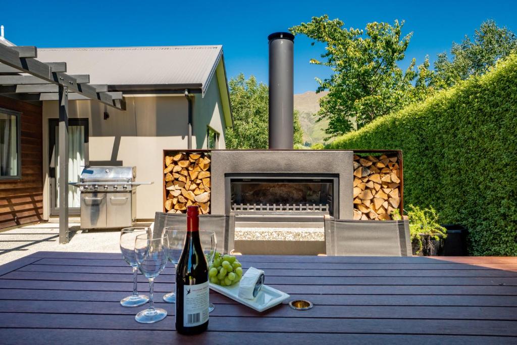 瓦纳卡Modern Lake Haven - Wanaka Holiday Home的一张桌子,上面放着一瓶葡萄酒和酒杯