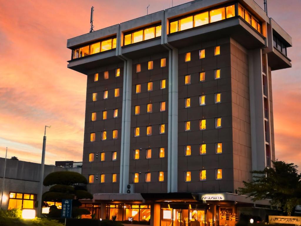 八户市Hachinohe Plaza Hotel的一座拥有许多窗户的建筑,日落时分
