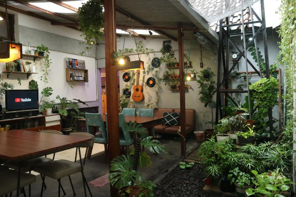 玛琅SEMERU HOSTEL MALANG的一间满是植物和桌子的房间