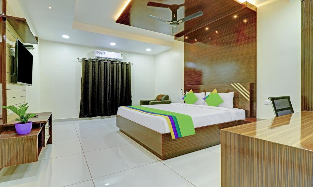 维杰亚瓦达Treebo Trend Arka Vijayawada的配有一张床和一张书桌的酒店客房