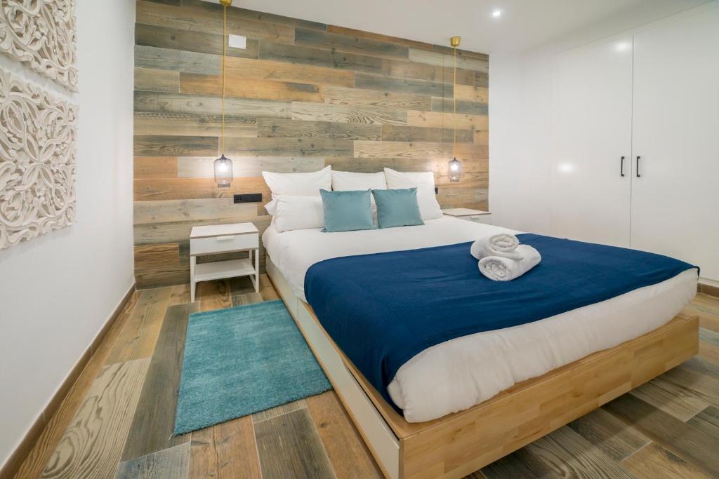 塞拉内华达Bed and Snow Family Apartments的一间卧室设有一张带木墙的大床