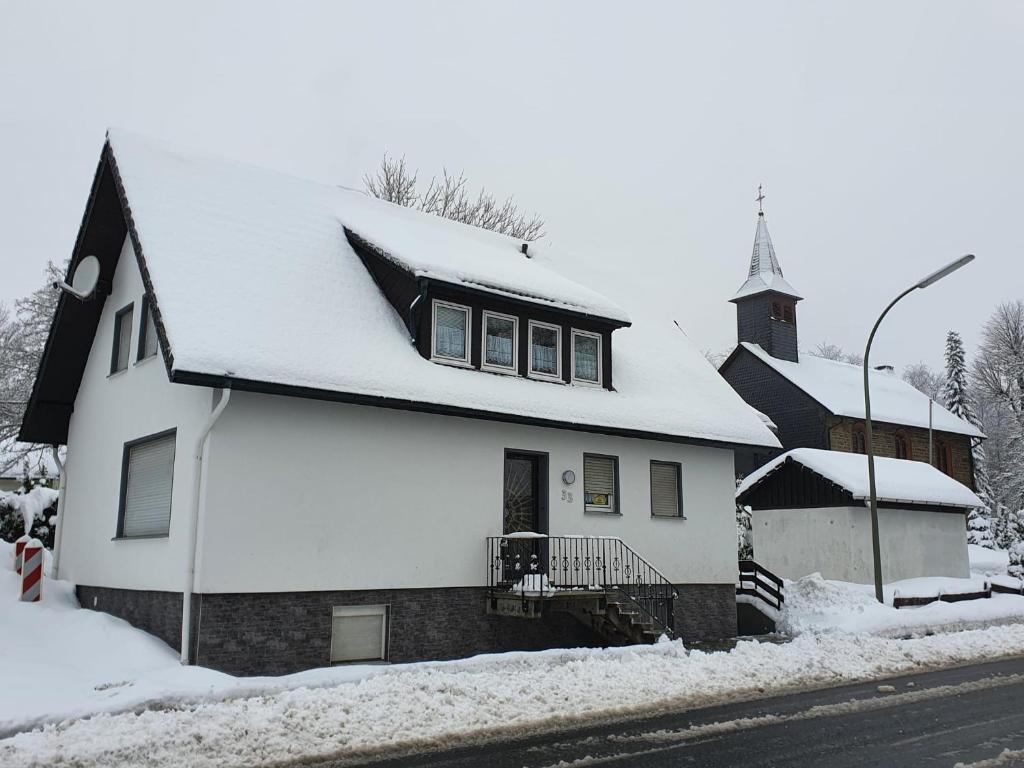 温特贝格Ferienhaus Trudi的白色的教堂,有雪盖屋顶