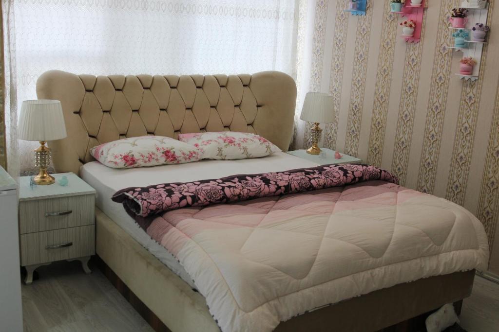 SeyhanSAYDAM OTEL的一间卧室配有一张大床、两盏灯和一个窗户。