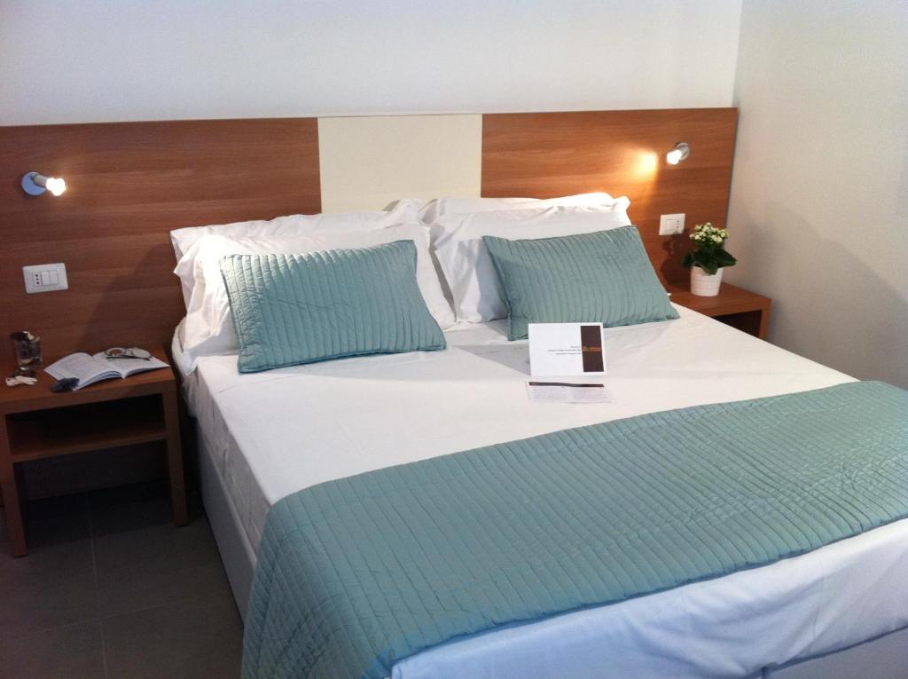 罗马假期S洛伦佐新旅馆的卧室配有带蓝色枕头的大型白色床