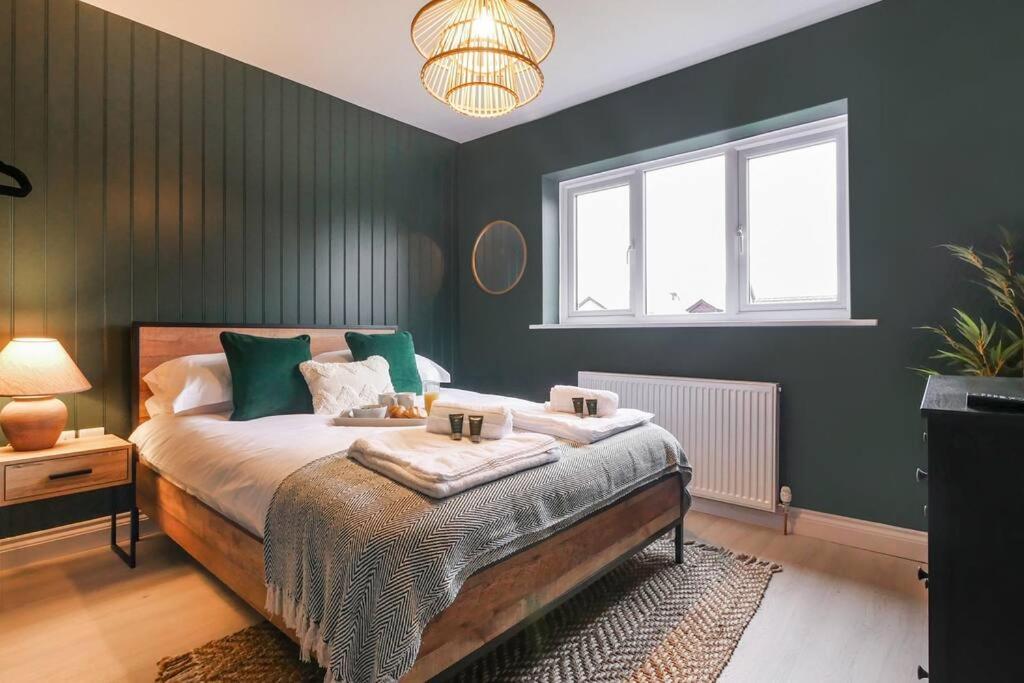 贝灵汉姆Hareshaw House的一间卧室设有一张带绿色墙壁的大床