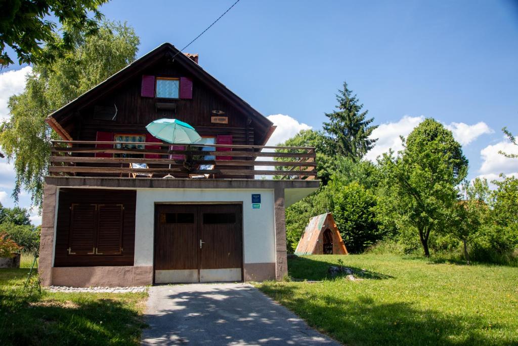 VrhovciMy dream house的一个带车库的吊桶屋顶的房子