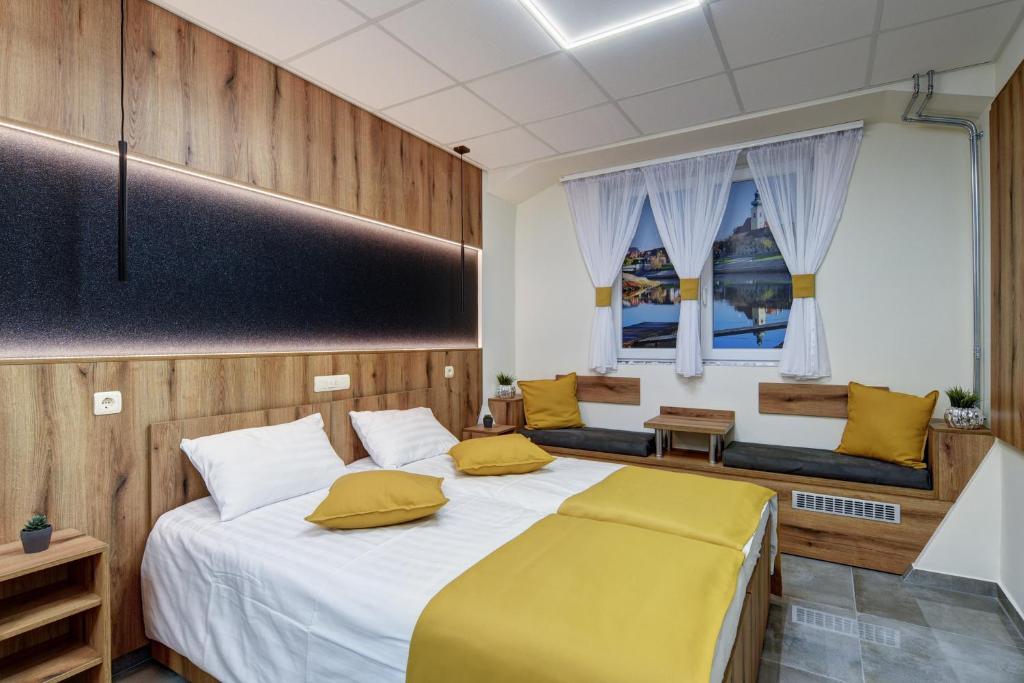 杰尔Riverside Inn - dunaparti szuterén的一间卧室配有一张带黄色枕头的大床