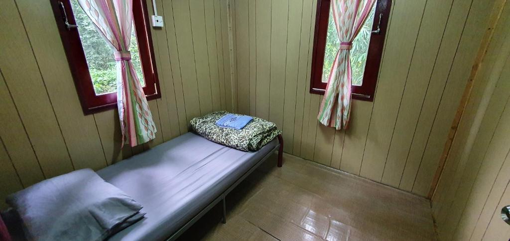 瓜拉江沙Chalet Kampong Guar, Manong的一张小床,位于带两个窗户的房间
