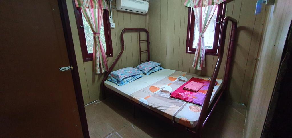 瓜拉江沙Chalet Kampong Guar, Manong的一张小床,位于带两个窗户的房间