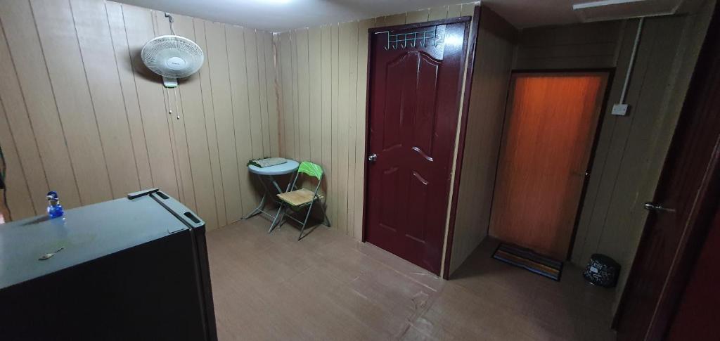 瓜拉江沙Chalet Kampong Guar, Manong的一间设有红色门、桌子和椅子的房间