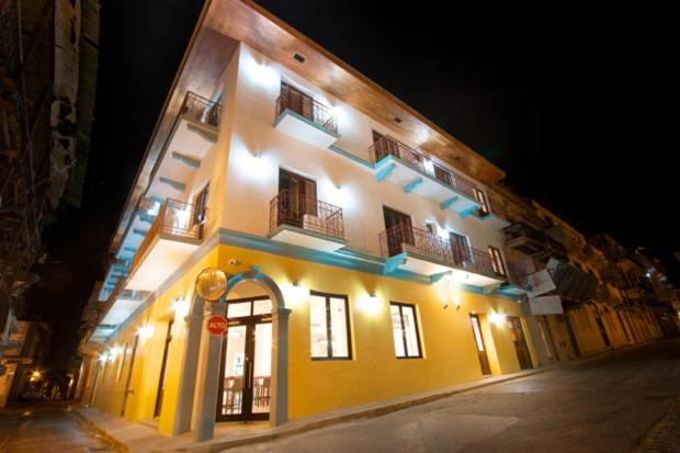 巴拿马城Tantalo Hotel - Kitchen - Roofbar的一座黄色的大建筑,晚上有灯