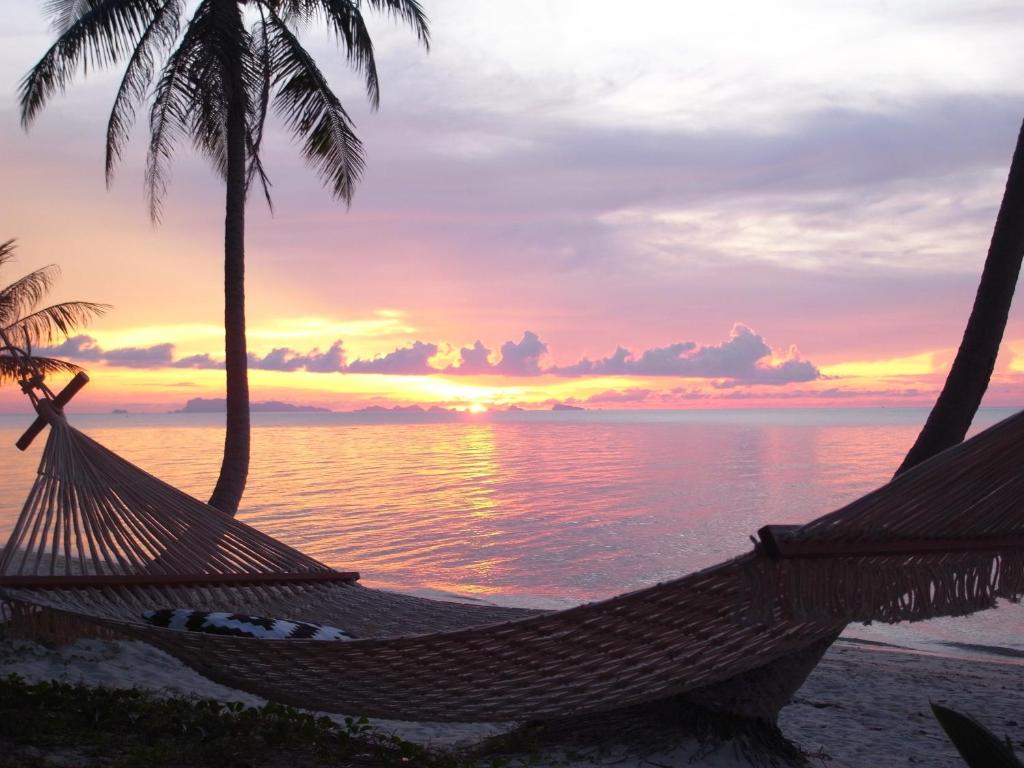 湄南海滩茉莉花和茶旅馆的海滩上的吊床和日落