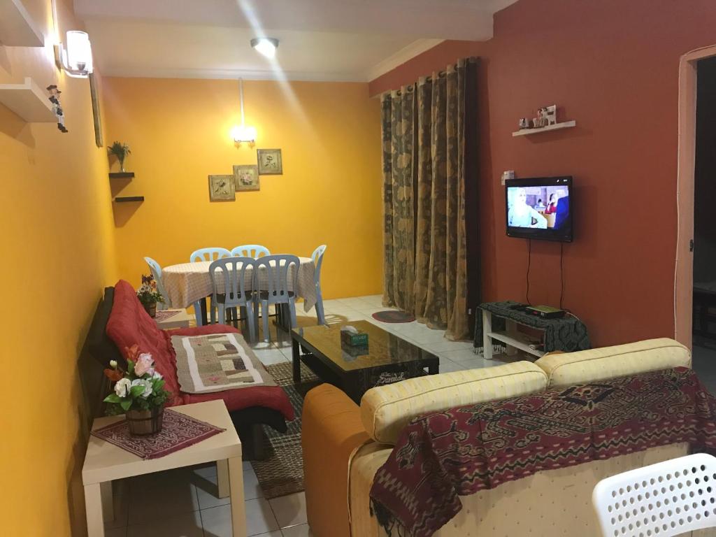 Kota SamarahanDesa Ilmu Homestay的带沙发的客厅和用餐室