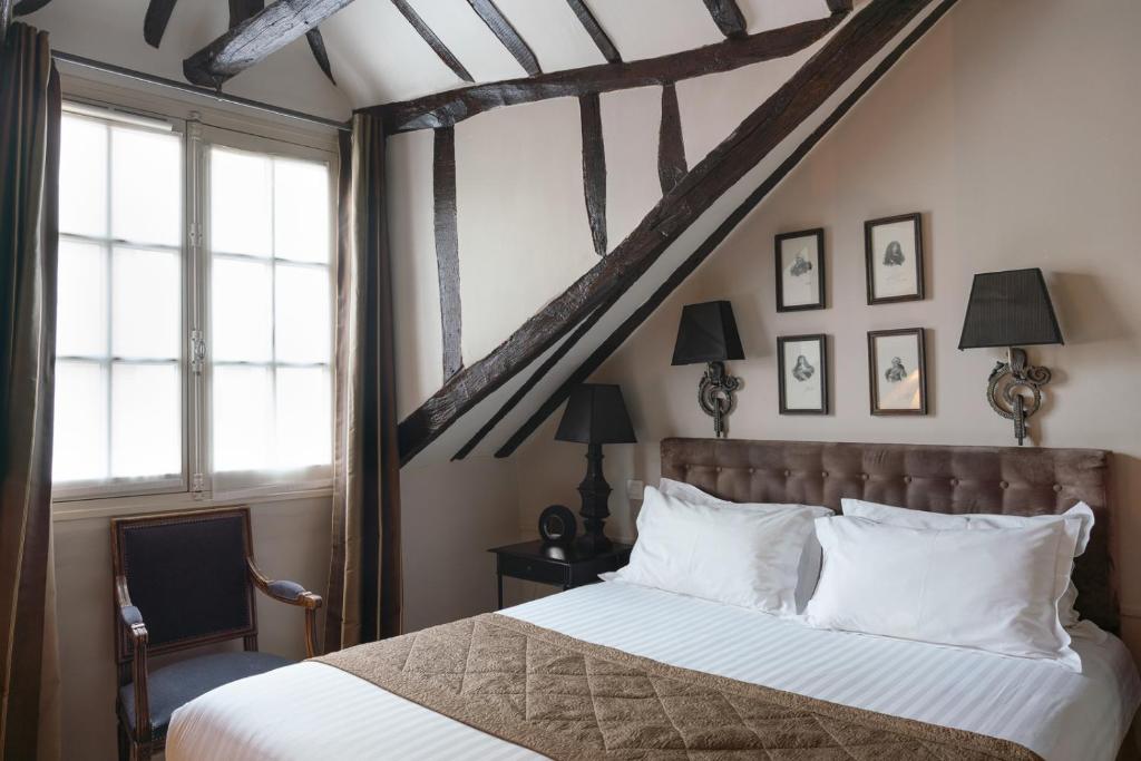 巴黎圣路易斯马莱酒店的卧室配有带白色枕头的大床