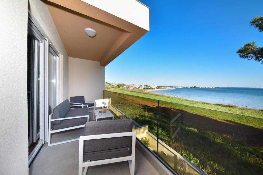 普利拉卡Beachfront villas with hot tubs Sun Garden的阳台配有椅子,享有海景。