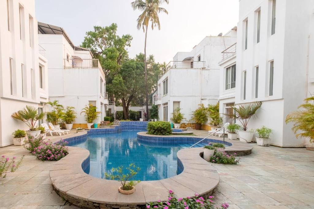 卡兰古特Snowdrop- Exquisite 3BHK Villa with Pool- Candolim By StayMonkey的白色建筑庭院中的游泳池
