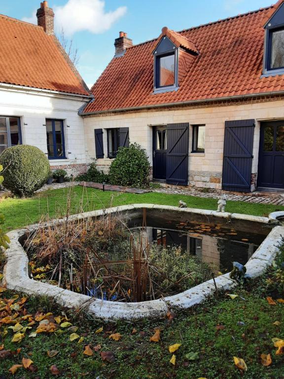 Capelle-FermontLa grange de Fermont的院子里有池塘的房子