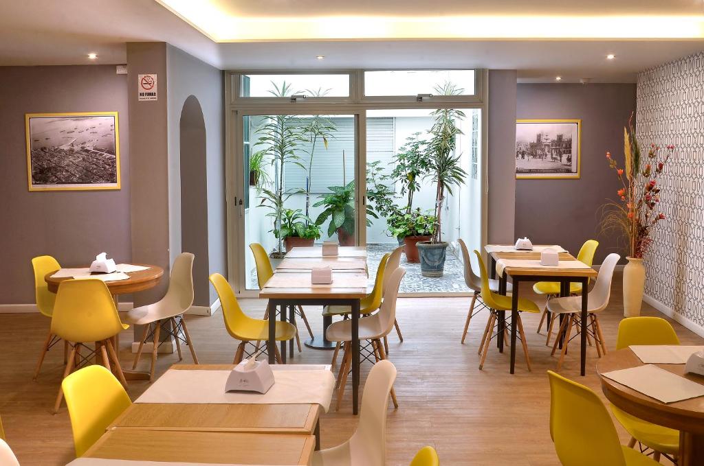 蒙得维的亚希斯潘诺酒店的餐厅设有木桌和黄色椅子