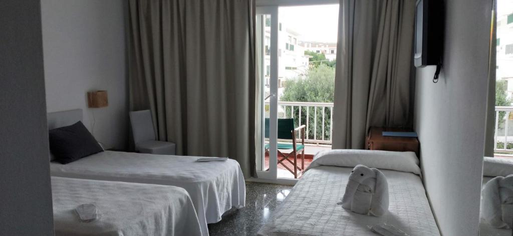 福尔内利斯Hostal S'Algaret的酒店客房设有两张床和一个阳台。