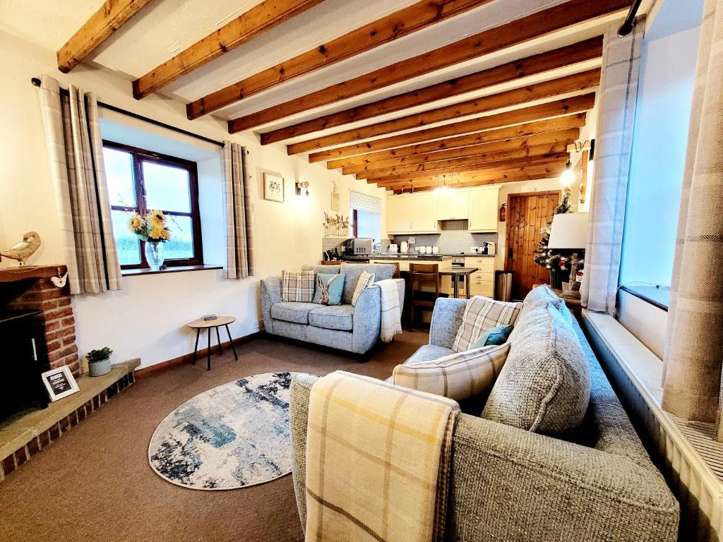 惠特比Grosmont Cottage, Ruswarp的客厅设有两张沙发和一个壁炉