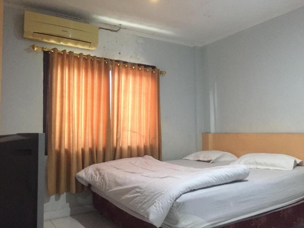沙璜Losmen PUM Syariah at Desa Wisata Sabang的一间卧室配有一张床和一个窗户,可避免噪音