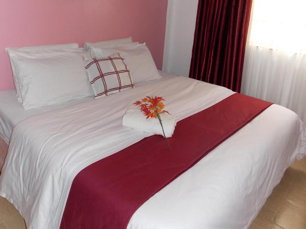 内罗毕Baraka Home的一张白色的床,上面有花