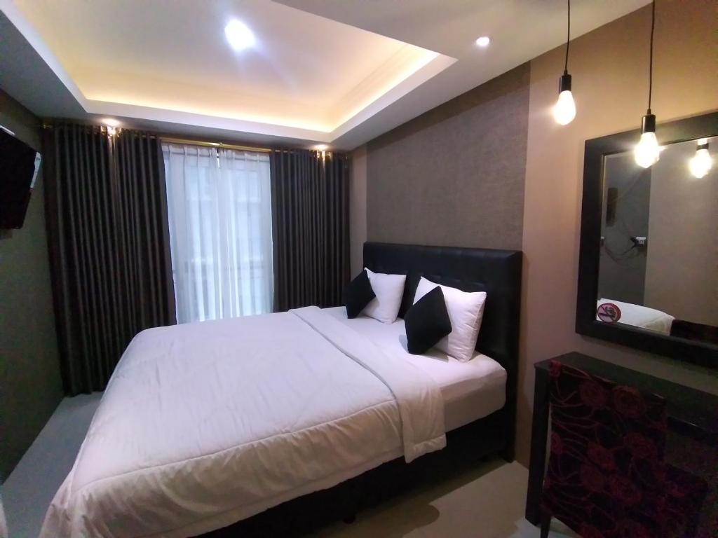 万隆Apartement Grand Asia Afrika Bandung by House Of Tofi的卧室配有一张带白色床单和枕头的大床。