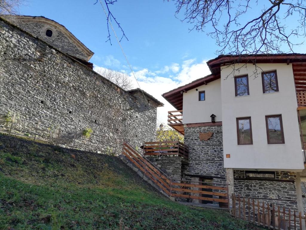 KosovoGUEST HOUSE ELENA的石墙旁的白色房子