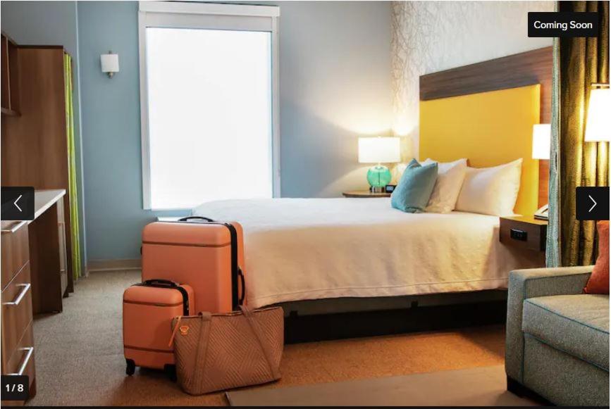 海沃德Home2 Suites By Hilton Hayward的酒店客房,配有一张带两个行李箱的床