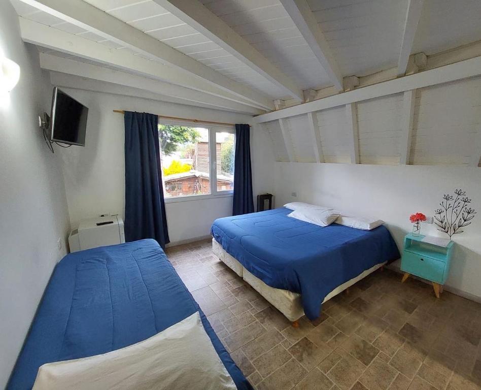 圣卡洛斯-德巴里洛切Ciao Bariloche - habitaciones privadas en hostel的一间卧室设有两张床和窗户。