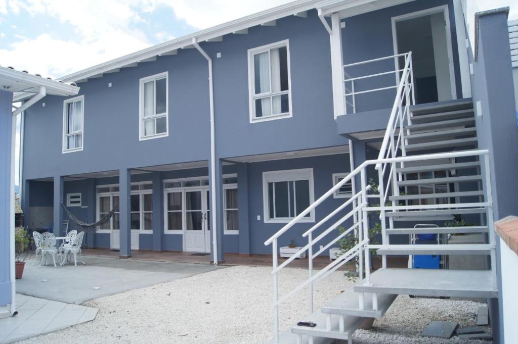 帕罗卡Casa com 2 quartos à 200 m da da praia c/ churrasqueira的蓝色房子前面有楼梯