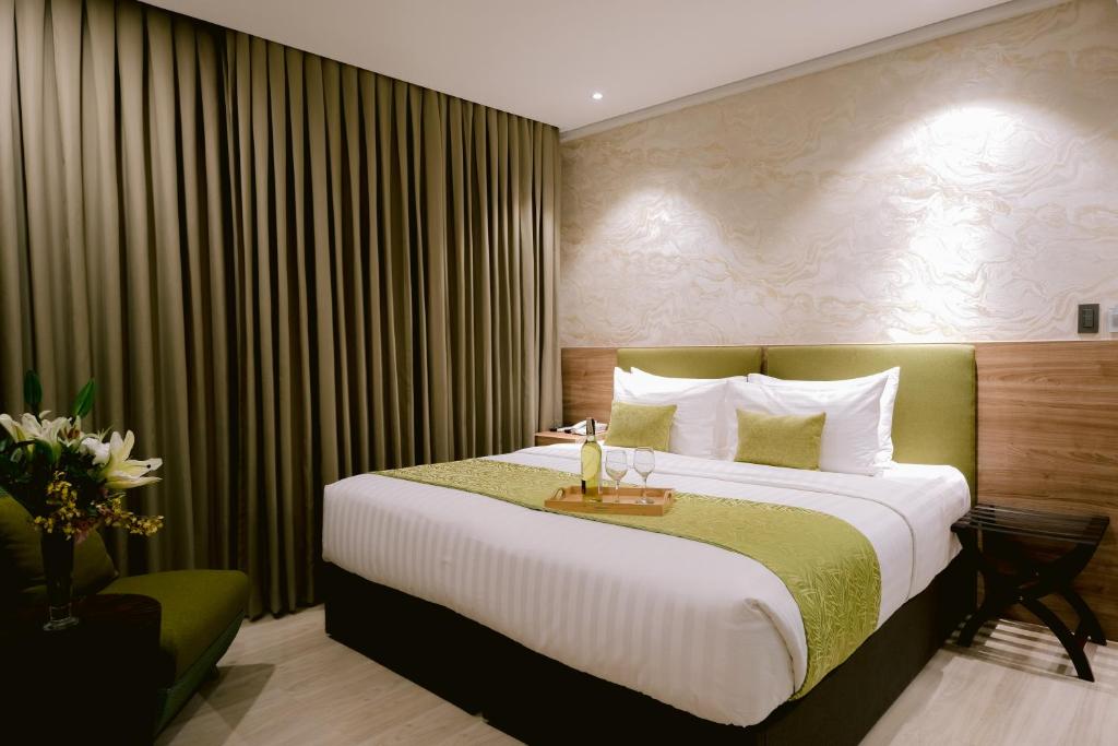 宿务Goldberry Suites and Hotel Cebu的酒店客房设有一张大床和一张桌子