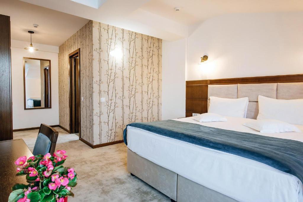 古拉哈莫卢洛伊Hotel Buchenland的配有床、桌子和鲜花的酒店客房