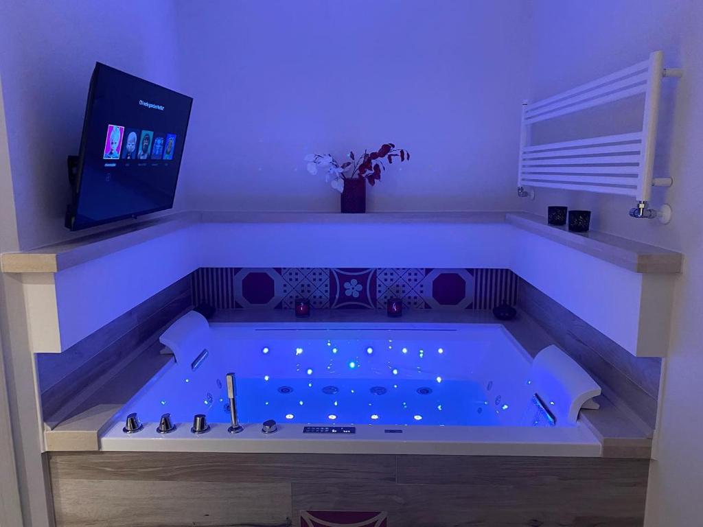 贝尔纳尔达MAD SUITES & APARTMENTS的客房内的按摩浴缸拥有蓝色的灯光