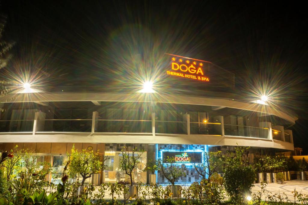 帕莫卡莱多加保健Spa酒店的一座晚上有杜莎标志的建筑