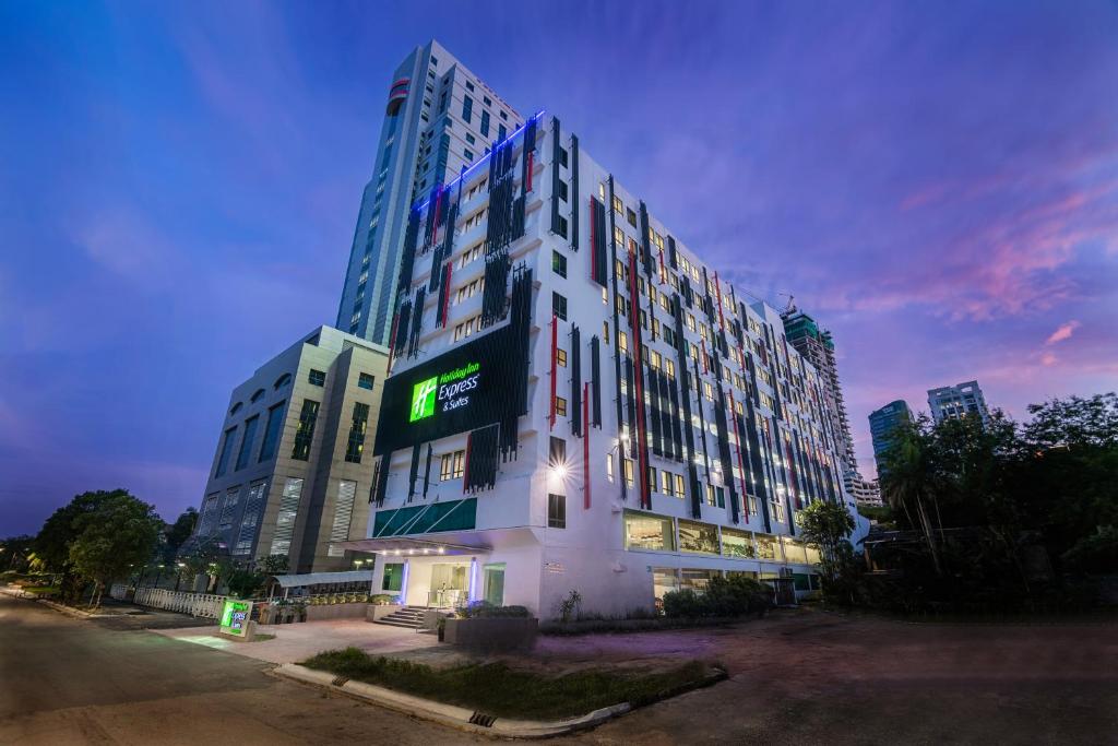 新山Holiday Inn Express & Suites Johor Bahru, an IHG Hotel的一座高大的建筑,旁边有一个标志