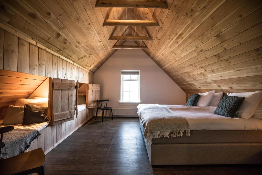 HaarleHerberg de Pas的一间卧室设有两张床和木制天花板